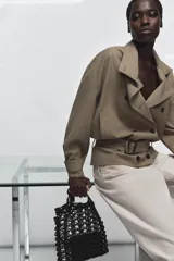 Bolso tipo shopper pequeño de crochet negro, con asas de hombro de material liso negro y una bolsa interior con cierre de cremallera.