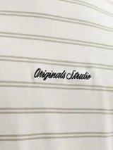 Remera de manga corta con diseño a rayas horizontales, cuello redondo y calce relajado. Cuenta con un pequeño detalle bordado en el pecho con la inscripción "Originals Studio".
