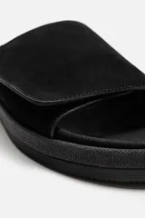 Sandalia abierta de hombre, fabricada en piel con acabado serraje, color negro. Tiene una tira ancha en el empeine con ajuste mediante cierre adherente, plantilla anatómica y suela plana a tono.