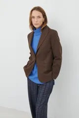 Blazer de corte clásico en color marrón, con cierre frontal de un botón, solapas con muesca y bolsillos laterales. Confeccionado en tejido estructurado.