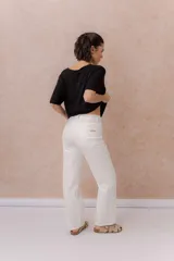 Jeans rectos blancos de tiro medio, con diseño clásico de cinco bolsillos, cierre de botón y bragueta, y perneras ligeramente amplias.