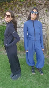 Conjunto de dos piezas compuesto por una campera de cuello alto con cierre frontal y mangas largas con orificios para pulgares, y un pantalón tipo babucha con cintura ajustable y puños elásticos en los tobillos. El diseño presenta una textura sutil en la tela.