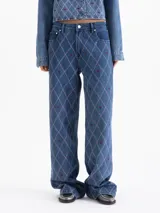 Jeans de denim azul, tiro medio y corte recto, con bordado integral en patrón de rombos en hilo rosa y pequeños bordados de labios en color bordeaux.