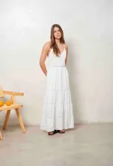 Vestido largo blanco de tirantes finos, con escote en V y detalles de inserciones de encaje broderie en la cintura y en la falda escalonada.