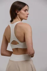 Top deportivo corto de sujeción media, con escote redondo y espalda abierta. Confeccionado en tejido elastizado de poliamida y spandex, con elástico interno en la cintura para mayor ajuste.