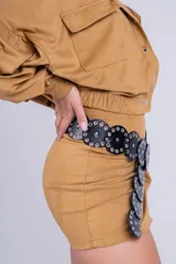 Minifalda negra de gamuza sintética con tajo lateral y cinturón con tachas plateadas.
