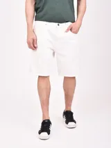 Bermuda blanca de jean, con corte recto y largo hasta la rodilla. Tiene bolsillos laterales y traseros.