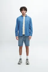 Camisa de manga larga celeste de denim con bolsillo en el pecho.