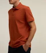 Remera polo de manga corta color verde militar, confeccionada en algodón peruano con cuello convencional y cierre de botones.