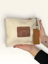 Sobre de cuero marrón con diseño pintado a mano que presenta al personaje Snoopy sobre un fondo rosado y la palabra 'heal'. Cuenta con cierre superior y etiqueta de cuero colgante.