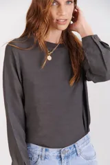 Blusa color crema de tela texturizada, con cuello en rib y puño camisero.