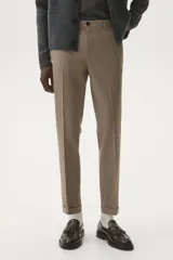 Pantalón de vestir color beige, de corte slim fit, con pinzas marcadas en el frente y dobladillo en el bajo.