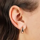 Aros tipo argolla pequeños, gruesos y con forma trapezoidal, de color oro rosado.
