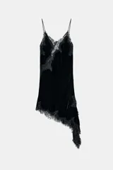 Vestido midi de terciopelo con escote en pico y tirantes finos. Presenta aplicaciones de encaje a tono y un diseño de bajo asimétrico.