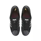 Championes Adidas modelo Superstar ADV, color negro con las icónicas tres tiras laterales en blanco. Presentan una capellada de gamuza, puntera de goma clásica y suela de goma con acabado oscuro.
