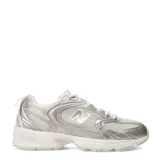 Championes urbanos New Balance modelo 530, con diseño retro inspirado en el running. Presentan una combinación de malla transpirable y revestimientos sintéticos en tonos beige y dorado metalizado, con la icónica letra N en los laterales y entresuela con tecnología ABZORB para mayor amortiguación.