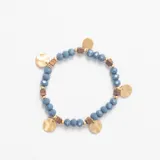 Pulsera elástica compuesta por cuentas facetadas de color azul, intercaladas con pequeñas piezas cúbicas de color marrón y cuentas esféricas doradas. Presenta dijes circulares planos en tono dorado distribuidos a lo largo de la pieza.
