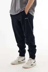 Pantalón de jogging azul marino de algodón grueso con interior cálido, corte amplio, tiro medio, cintura elástica con cordón, cierres en los tobillos y logo "vernal" bordado en la pierna izquierda.