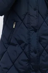 Campera acolchada de largo medio, color azul marino, con diseño de rombos. Posee cuello alto y capucha desmontable.