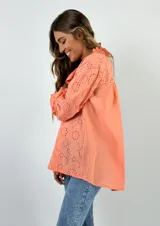 Camisa color beige con bordados florales y perforados, de corte holgado y manga larga.