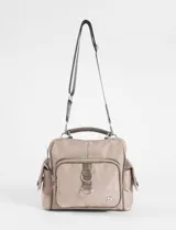 Bandolera convertible en mochila de color beige, confeccionada en poliéster. Cuenta con múltiples bolsillos externos con cierre, asa superior reforzada y correa ajustable y extraíble para llevar al hombro o cruzada.