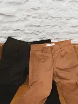 Pantalón de pana color marrón claro, de corte ancho y tiro alto, con bolsillos laterales y traseros.