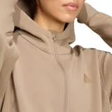Campera deportiva Adidas modelo Designed for Training, color caqui, con capucha, cierre frontal completo y bolsillos laterales con cierre. Presenta el logo de la marca sutilmente bordado en el pecho.