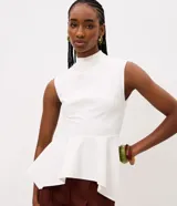 Blusa azul marino sin mangas de la marca Cortelle, con cuello alto, recortes estructurales y dobladillo estilo peplum asimétrico.