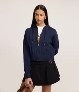 Campera corta de punto azul marino, con capucha ajustable por cordón, cierre frontal por cremallera y bajo ajustado.