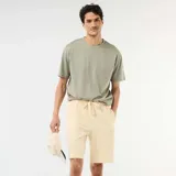 Bermuda de felpa ligera color amarillo claro, con cintura elástica y cordón ajustable.
