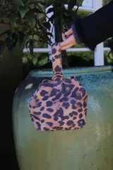 Mini bag tipo limosnera con estampado animal print de leopardo y asa corta.