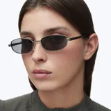 Lentes de sol con montura rectangular de acero inoxidable en color gris mate y lentes polarizadas negras. Presentan un diseño minimalista con varillas metálicas y terminales de acetato.