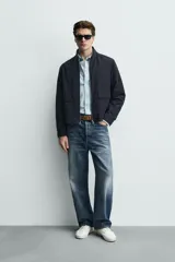 Sobrecamisa de corte regular fit en tejido técnico negro resistente al agua, con cuello estilo bomber en rib elástico, cierre frontal de cremallera y bolsillos plastrón con solapa en la cadera.