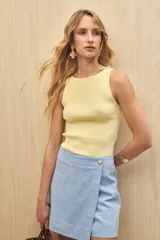 Musculosa blanca de punto acanalado, sin mangas, con cuello a la base y calce al cuerpo.