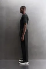 Pantalón jogger relaxed fit Zara Athleticz de tejido técnico compacto elástico con mezcla de algodón. Presenta cintura elástica ajustable con cordón, bolsillos laterales en la cadera, bolsillo trasero con cierre de cremallera, bajo ajustable con elástico y detalle de logo estampado en la pernera.