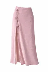 Falda midi de color rosado con textura de encaje floral, presenta una abertura lateral con lazos decorativos ajustables.