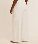 Pantalón de sastrería modelo pantalona color blanco, de corte ancho y recto, con cintura elástica con trabillas, bolsillos laterales y un cinturón de lazo ajustable en la misma tela.