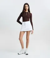 Blusa de punto color blanco con cuello polo, manga larga y detalles de ribete en contraste color negro en el cuello, puños y ruedo. Confeccionada en mezcla de viscosa, poliéster y poliamida.