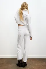 Jeans de mujer, tiro alto, color azul medio con efecto desgastado (lavado claro en muslos y oscuro en bordes). Corte recto y ancho (mom fit) con cinco bolsillos y cierre frontal de botón y cremallera.