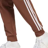 Pantalón de jogging marrón con cintura elástica y logo de Adidas bordado en blanco.