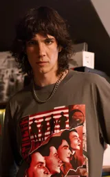 Remera de manga corta con cuello redondo y calce oversize, color gris oscuro. Presenta un estampado frontal con estética retro que incluye figuras humanas y una computadora antigua en tonos rojos.