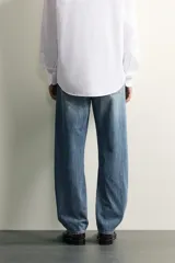Jeans regular fit de mezclilla negra con efecto lavado, corte recto y tiro medio. Cuenta con diseño de cinco bolsillos y cierre frontal con cremallera y botón.