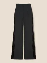 Pantalón negro de vestir de corte recto con cintura media y detalle de trenza de terciopelo calada en los laterales.