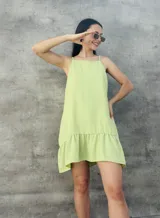 Vestido corto verde lima con textura plumeti, corte suelto, breteles finos y volado en el ruedo.