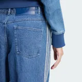 Jean de corte holgado y tiro medio, confeccionado en denim azul. Presenta las icónicas tres tiras de la marca en los laterales y el logo del trébol bordado en la parte frontal.