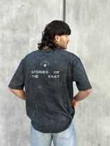 Remera oversize gris con efecto lavado y estampado en la espalda con la frase "STORIES OF THE EAST".