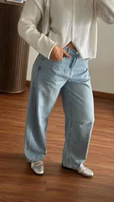 Pantalón de denim estilo barrel en color celeste claro, de tiro medio y diseño amplio en las piernas.