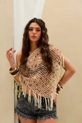 Top corto tejido en crochet de color crudo, con diseño de red adornado con lentejuelas y flecos colgantes en el dobladillo. Presenta un corte asimétrico de un solo hombro.