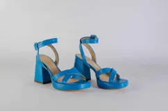 Sandalias de plataforma color celeste con tiras cruzadas y tobillera con hebilla. Plataforma de 9,5 cm.