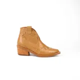 Botín de cuero vacuno color marrón oscuro, con taco de madera foliado en cuero de 5cm de altura, cierre lateral interno y horma de punta fina.